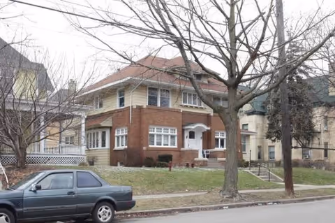 Exterior view of Lyon Street Adult Foster Care building with a car parked on the street.