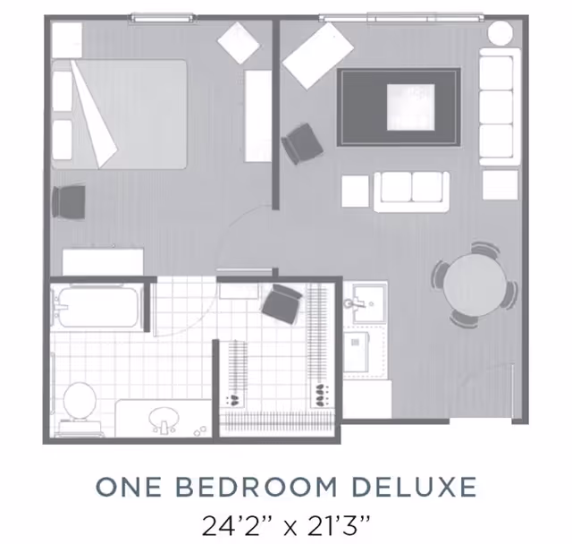 Floor plan of a one bedroom deluxe apartment showing a bedroom with a bed and chair, a bathroom with a bathtub, toilet, and sink, a walk-in closet, and a living room area with sofas, chairs, a coffee table, a round dining table with chairs, and a kitchen sink area.