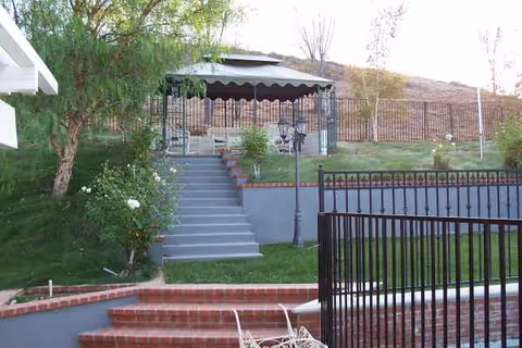 Outdoor courtyard at The Norma J's Home for the Elderly with gazebo and brick steps.