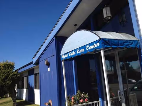 Blue building exterior with entrance awning and signage reading Royal Oaks Care Center.