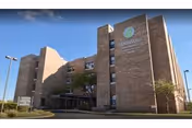 Brick exterior of Peninsula Nursing and Rehabilitation facility with entrance and surrounding landscaping.