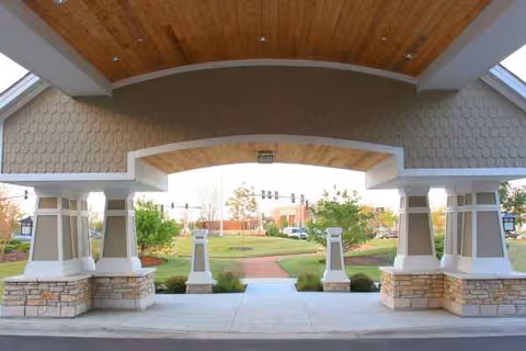 Exterior entrance of Chestnut Square at the Glen with a curved arch and supportive pillars.