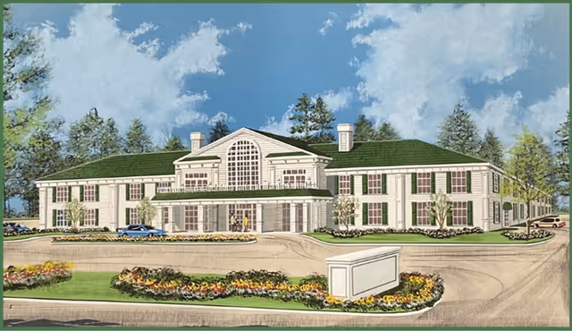 Illustration of a large two-story senior living facility building with a green roof, multiple windows with green shutters, and a central entrance with a covered porch. The building is surrounded by landscaped gardens with colorful flowers and trees under a partly cloudy blue sky.