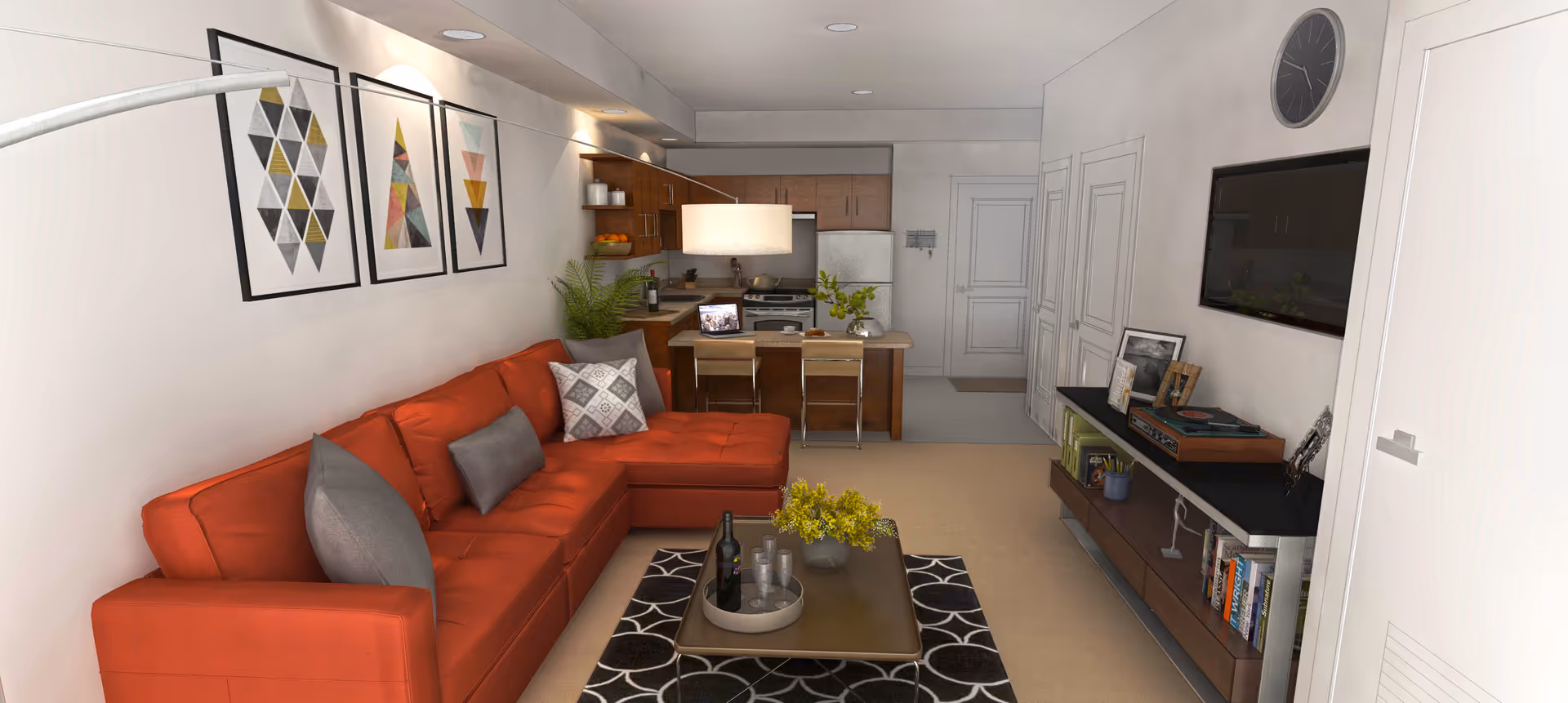 A modern living room and kitchen area featuring a red sectional sofa with gray pillows, a coffee table with a wine bottle and glasses, and a patterned rug. The kitchen has wooden cabinets, a refrigerator, stove, and a small island with two chairs. The room is decorated with three framed geometric art pieces on the wall, a large wall clock, a flat-screen TV, and various decorative items on a console table.