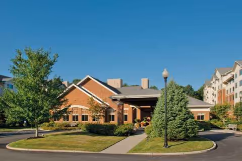 Exterior view of Brooksby Village building with brick facade and landscaped entrance.
