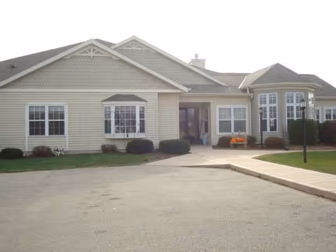 Single-story senior living facility exterior with a front entrance and landscaped walkway.