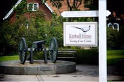 Exterior view of Kimball Farms Nursing Care Center with sign and decorative cannon near walkway.