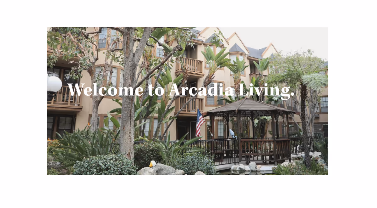 Courtyard of Arcadia Living showing a wooden gazebo, pond, landscaping and a multi-story residential building with balconies in the background.