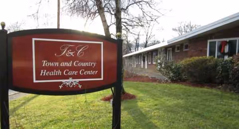 Sign reading Town and Country Health Care Center in front of a brick building.