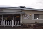 Exterior view of Alpine Meadow Rehab & Nursing with porch and sign.