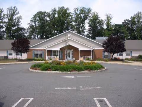 Front view of Arden Courts Whippany senior living facility with circular driveway and landscaping.