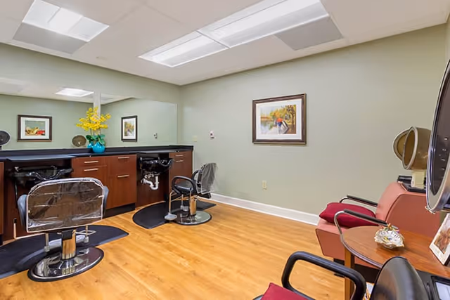 Interior salon with styling chairs, shampoo sinks, mirrors, and waiting chairs.