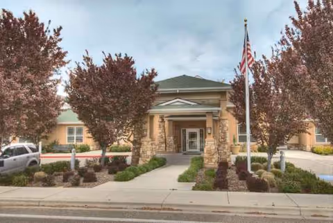 Exterior view of Emerson House at Riverpointe entrance with flagpole and landscaped walkway.