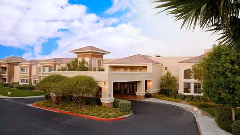 Atria Seville senior living facility front entrance with curved driveway and landscaping.