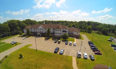Aerial view of Liberty Arms Assisted Living building with parking lot and green grounds.