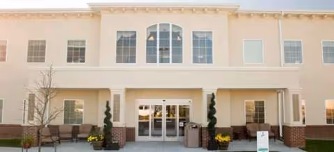 Exterior view of Brookdale Overland Park building front with glass doors and seating.