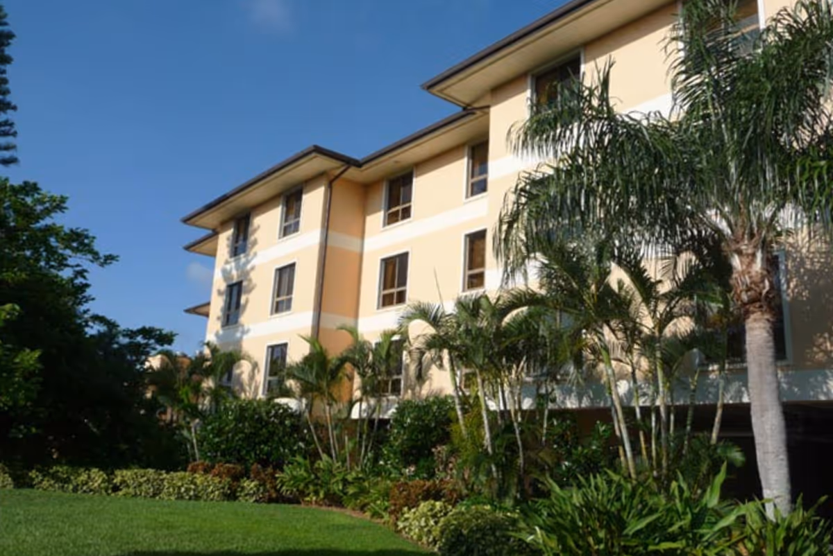 Exterior view of King's Crown senior living facility surrounded by greenery.