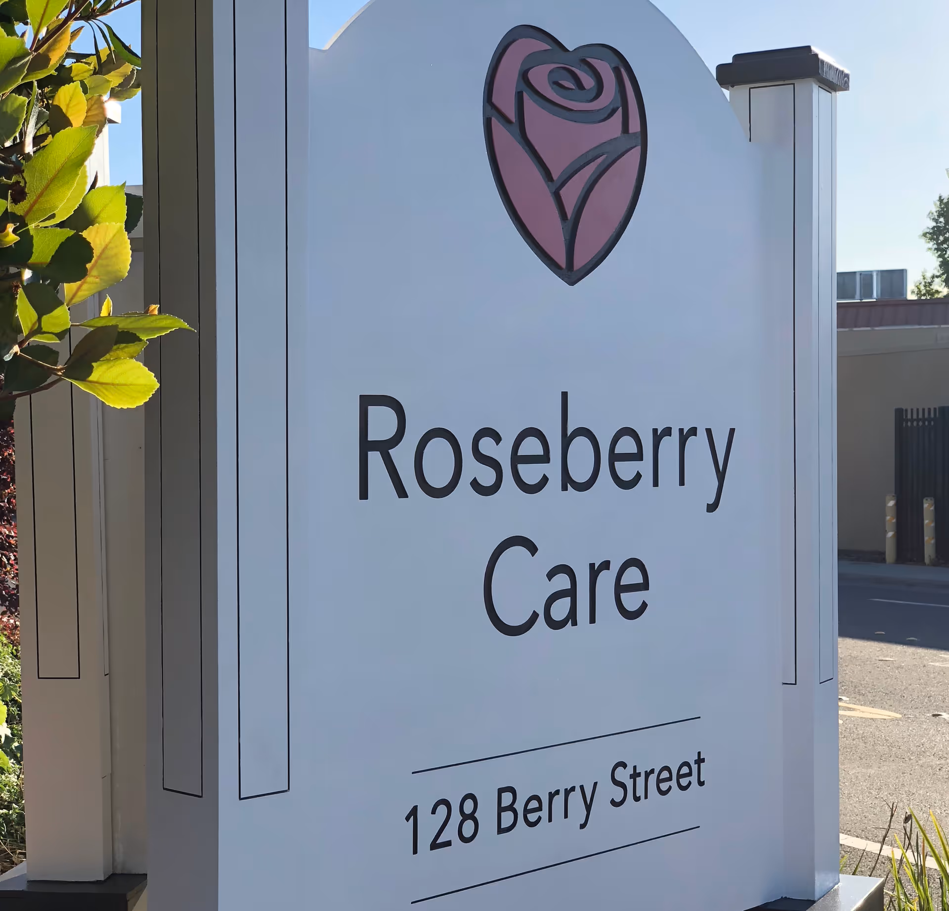 Outdoor sign reading "Roseberry Care" with a rose logo and the address 128 Berry Street.