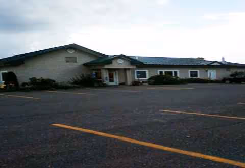 Single-story senior care building with a parking lot in the foreground.