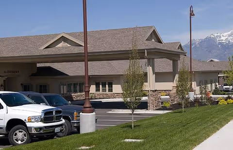 Carrington Court Assisted Living exterior view with parked cars and a landscaped front entrance.