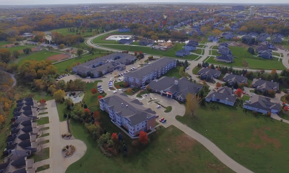 Aerial view of the Silvercrest at Woodlands Creek campus showing multiple residential buildings, parking areas, roads and surrounding green lawns.
