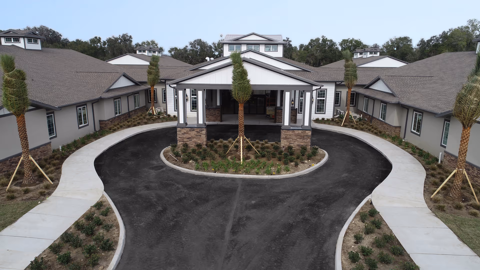 Front entrance of AdviniaCare at Paddock Ridge showing a covered portico, circular driveway, and landscaped grounds.