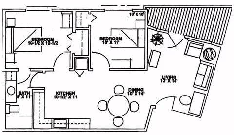 Architectural floor plan of a residential unit showing two bedrooms, a bathroom, a kitchen, a dining area with a round table and four chairs, and a living room with seating furniture and a fireplace.