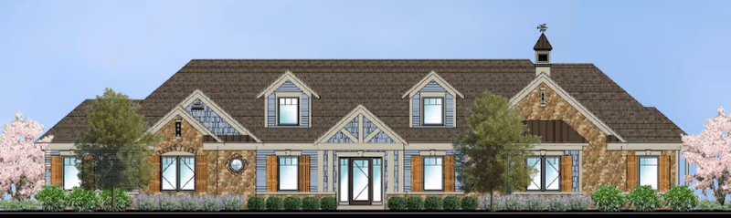 Front exterior view of a single-story building with a combination of stone and siding facade, multiple windows with shutters, dormer windows on the roof, a central entrance with glass doors, and landscaping including trees and bushes.