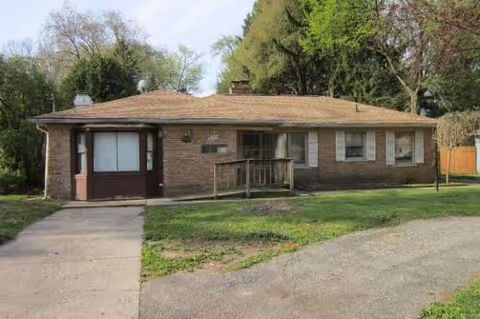 Front exterior of a single-story brick building with a ramp and green lawn.