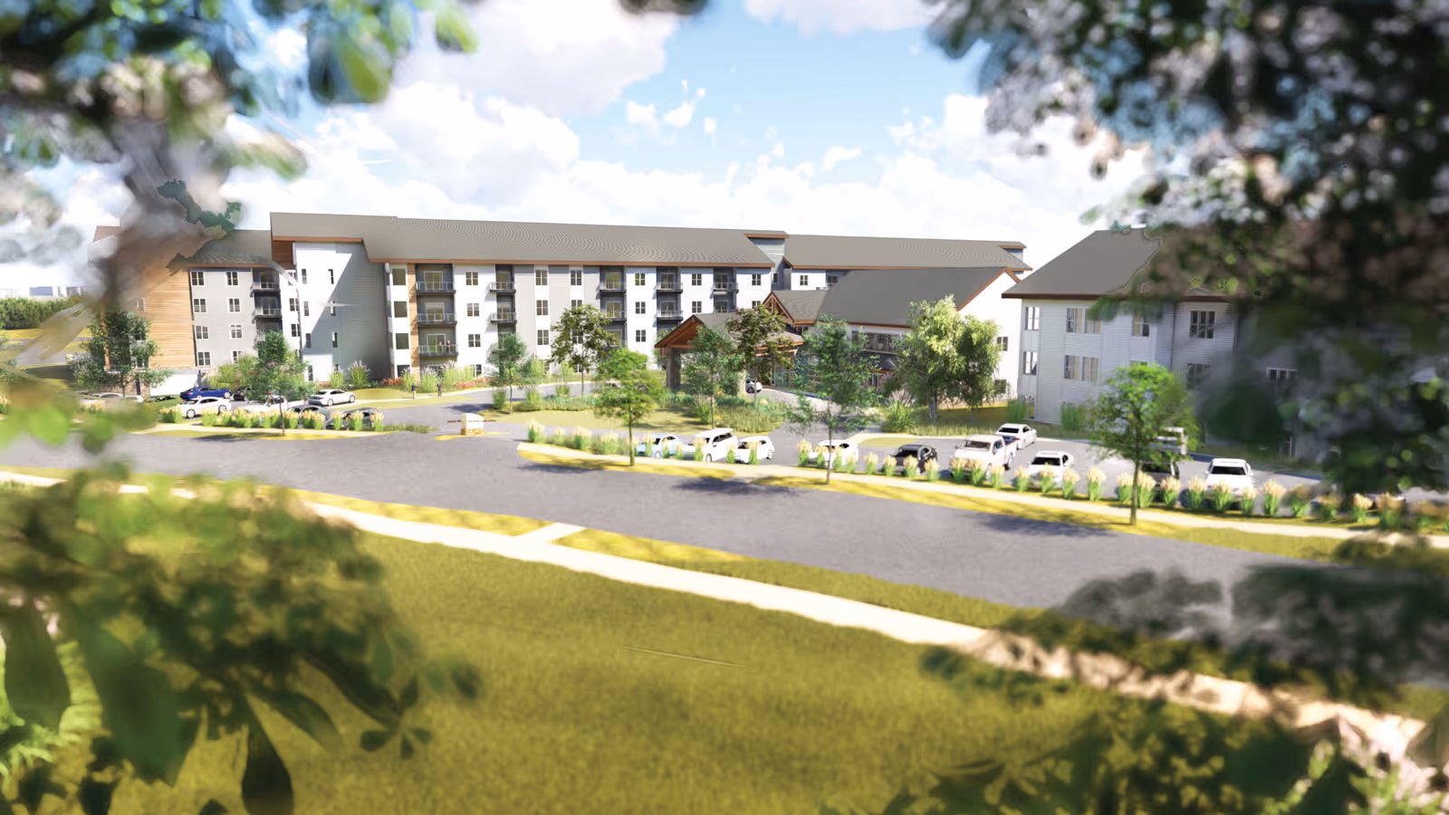 Exterior view of a multi-story senior living facility building with a parking lot in front, surrounded by trees and greenery under a partly cloudy sky.
