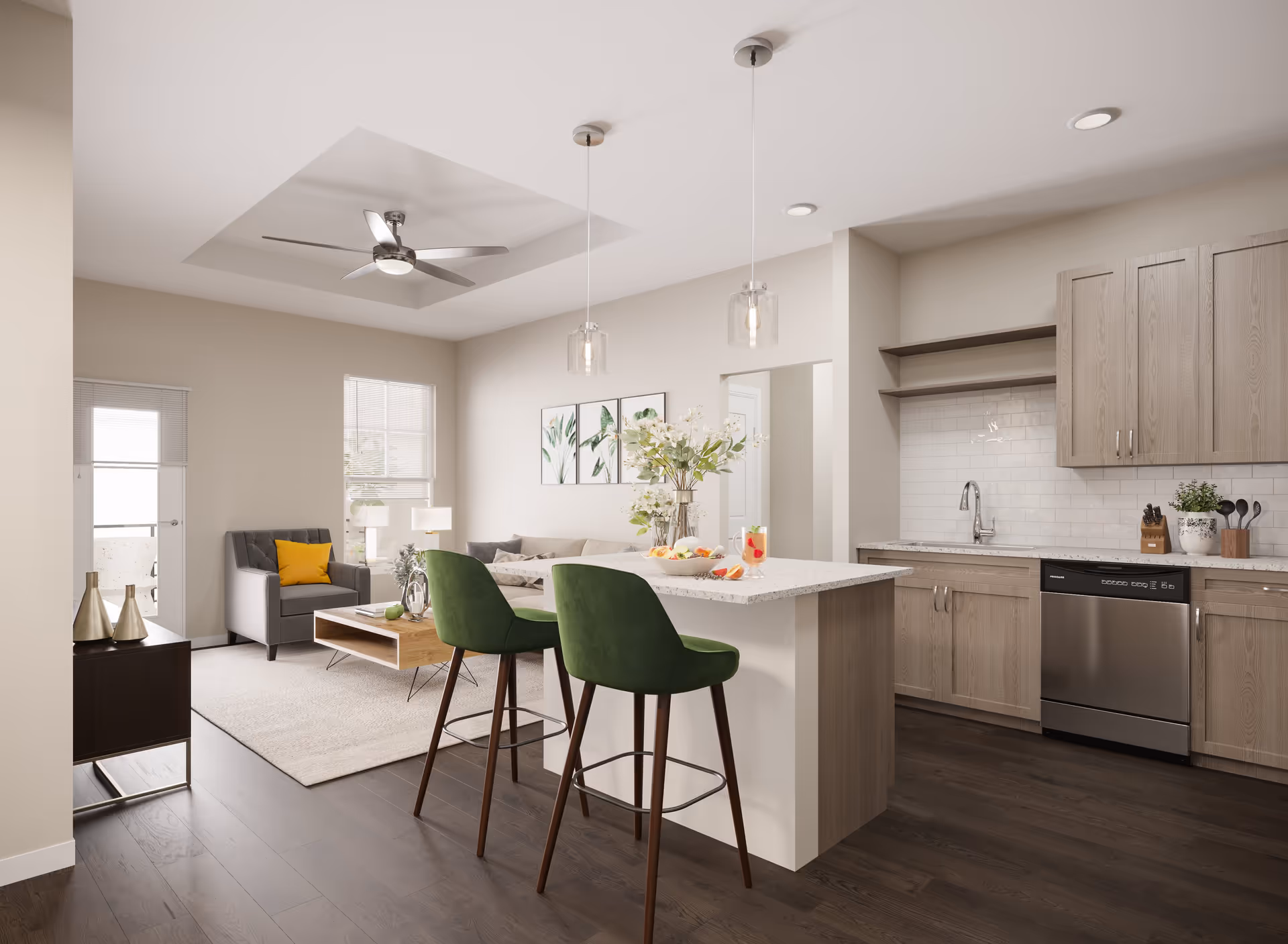 Modern open-concept living space featuring a kitchen with light wood cabinets, a white countertop island with two green bar stools, and a living room area with a gray armchair, a beige sofa, a wooden coffee table, and wall art. The room has dark wood flooring, recessed lighting, and a ceiling fan.