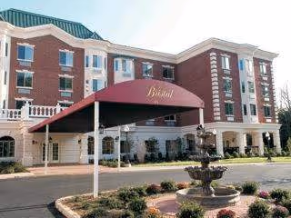 Exterior view of The Bristal Assisted Living at North Hills with entrance canopy and fountain
