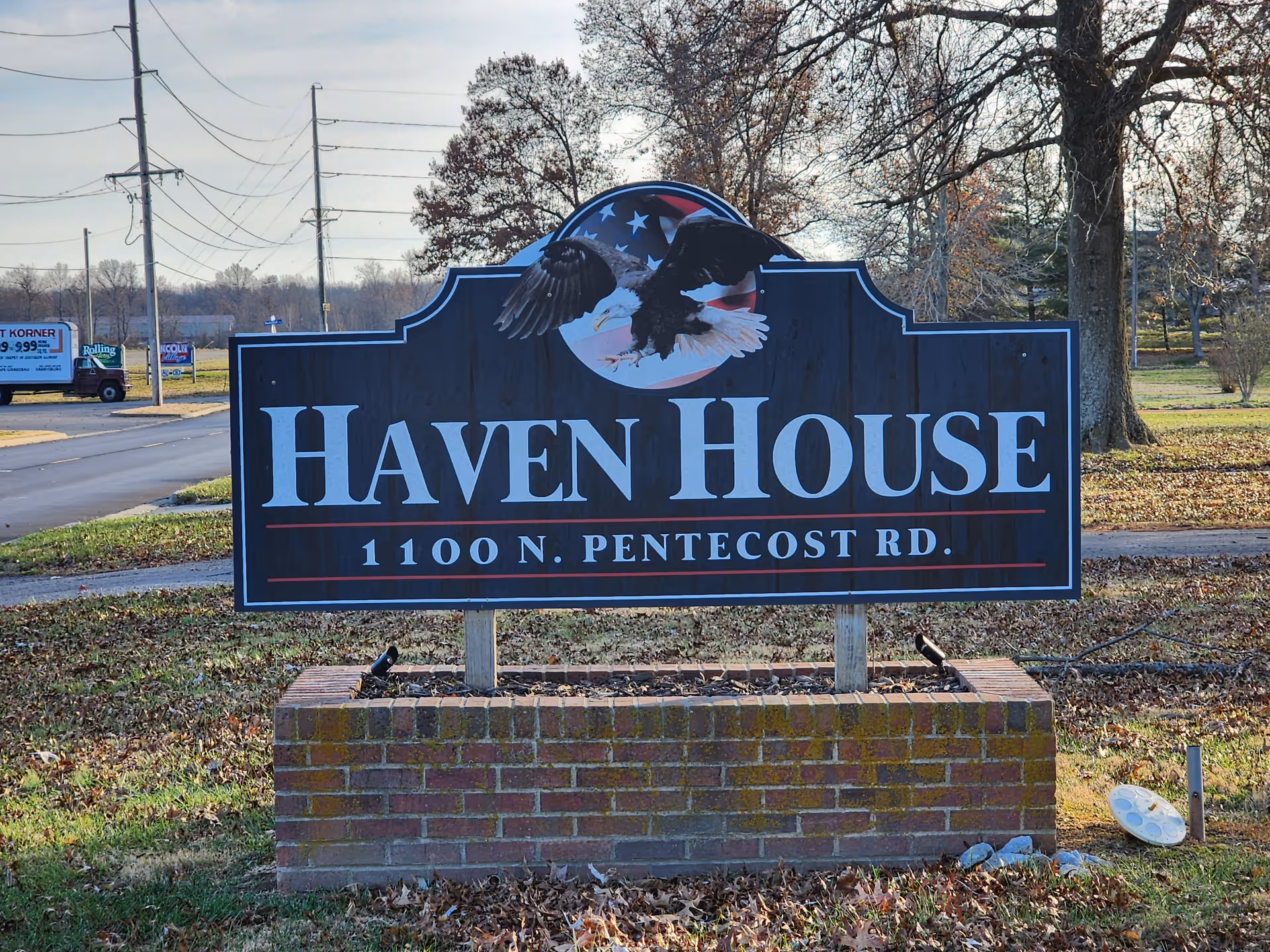 A large sign in a brick planter reads "Haven House 1100 N. Pentecost Rd." with an eagle logo in a grassy outdoor setting.