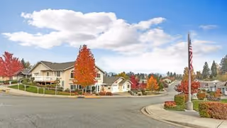 Exterior view of Horizon Village senior living along a curved street with fall trees.