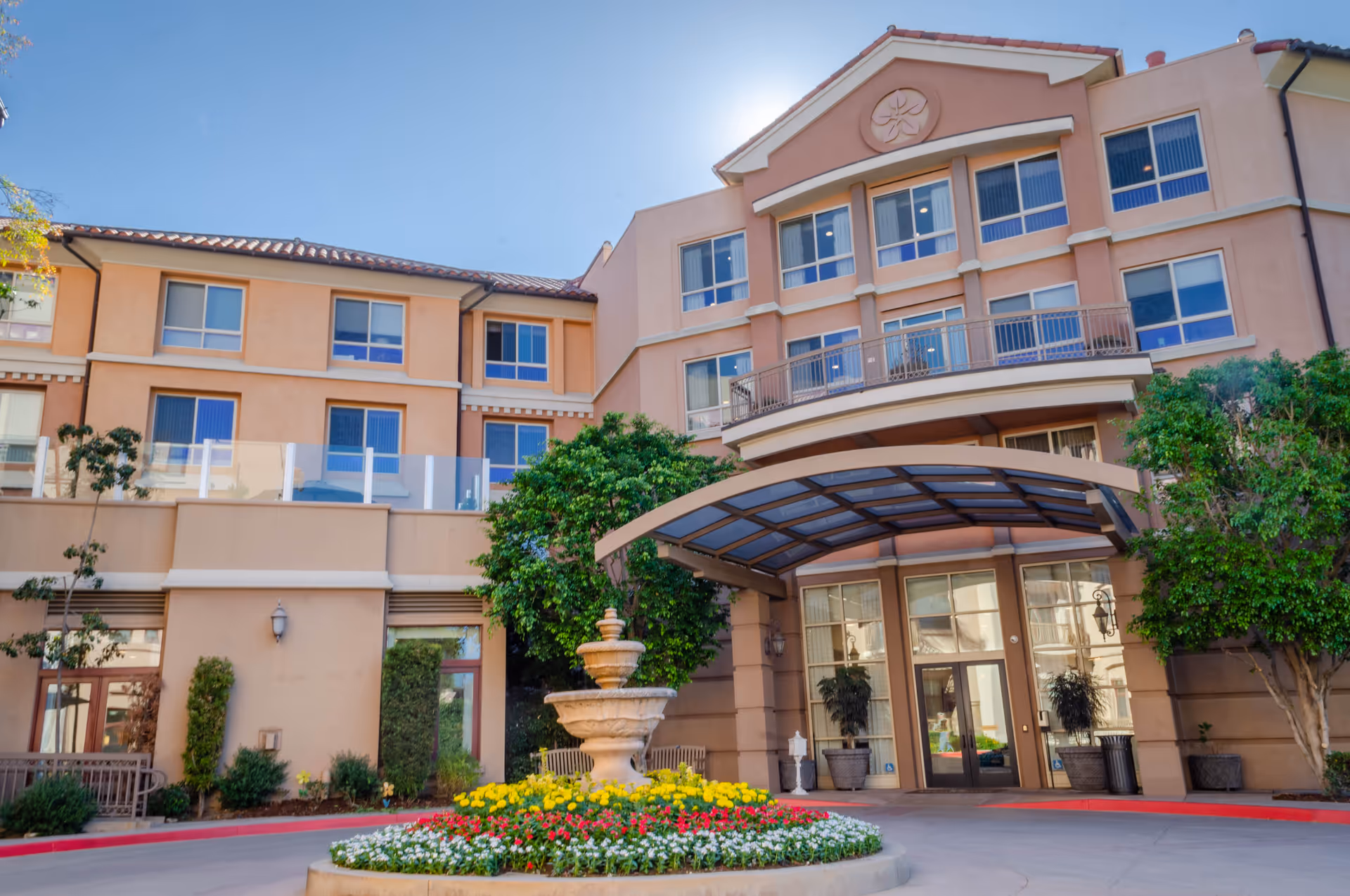 Front exterior view of MorningStar of Pasadena building with fountain and landscaped courtyard.