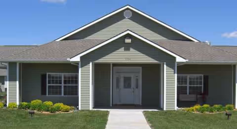 Front exterior of Council Grove Assisted Living with a covered entry and manicured lawn.