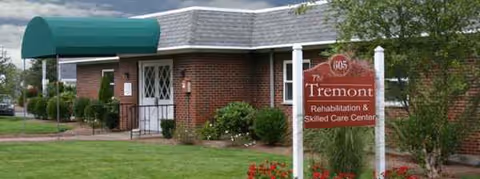 Brick exterior of Tremont facility features a green awning and front sign.