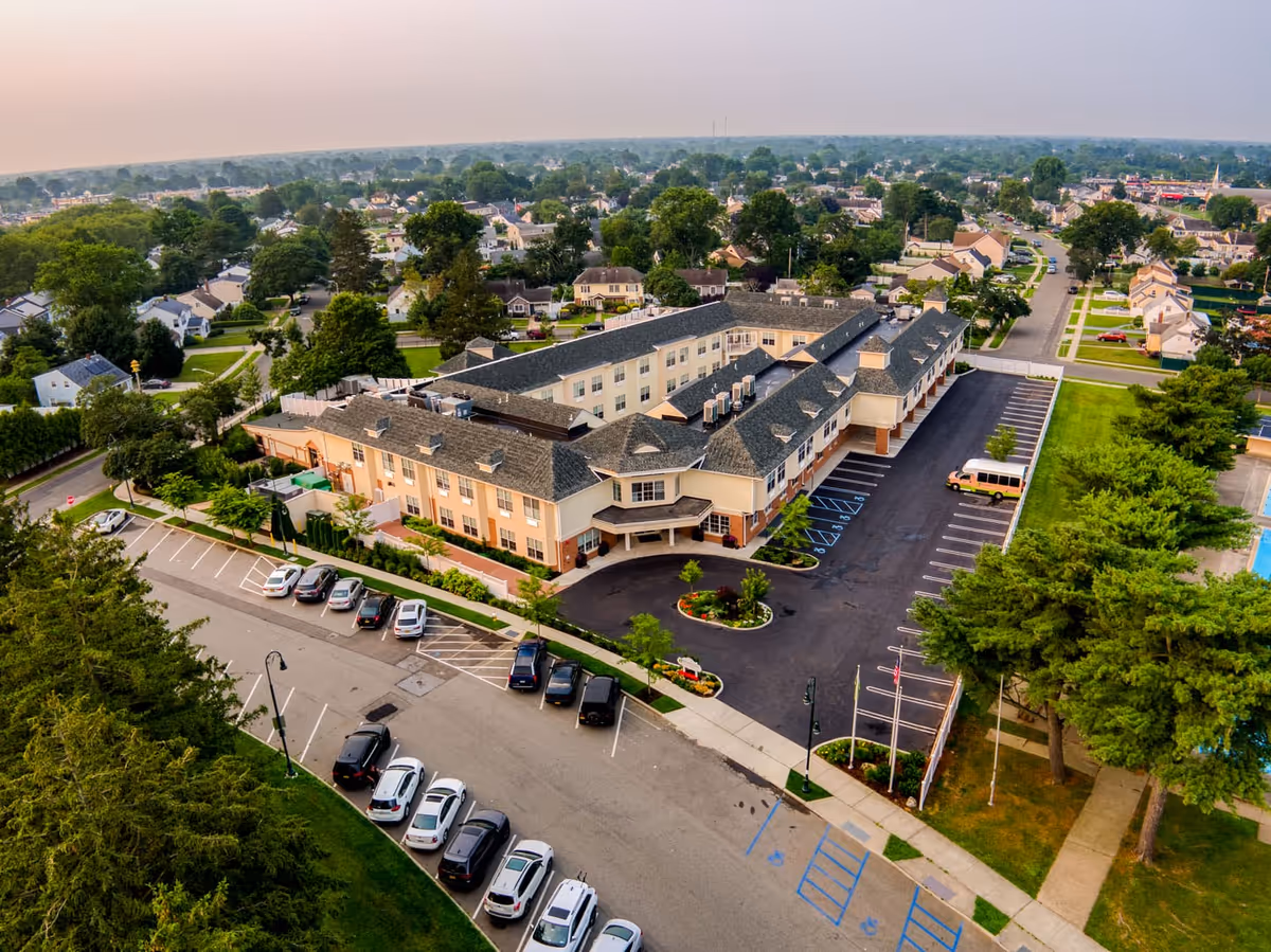 Aerial view of Village Green senior living campus with parking and surrounding neighborhood.