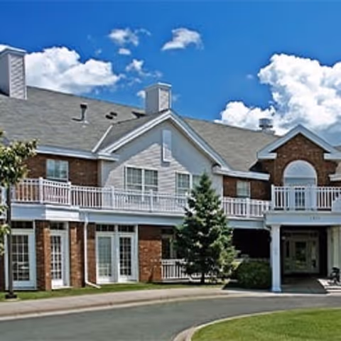 Exterior view of Woodbury Estates senior living facility with brick facade and balconies.