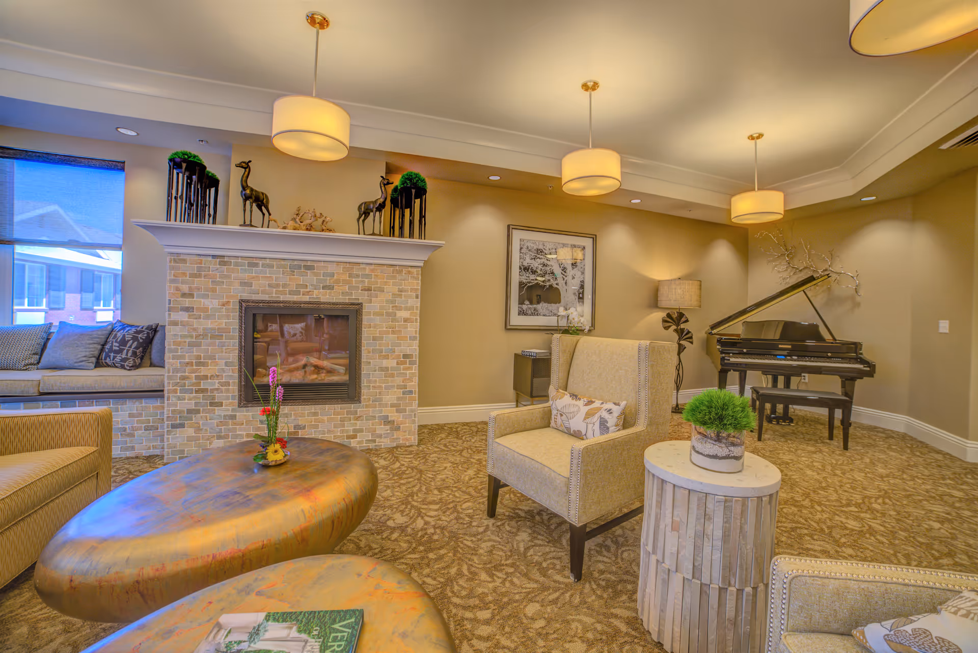 Comfortable lounge area with armchairs, a fireplace, decorative tables, and a grand piano.