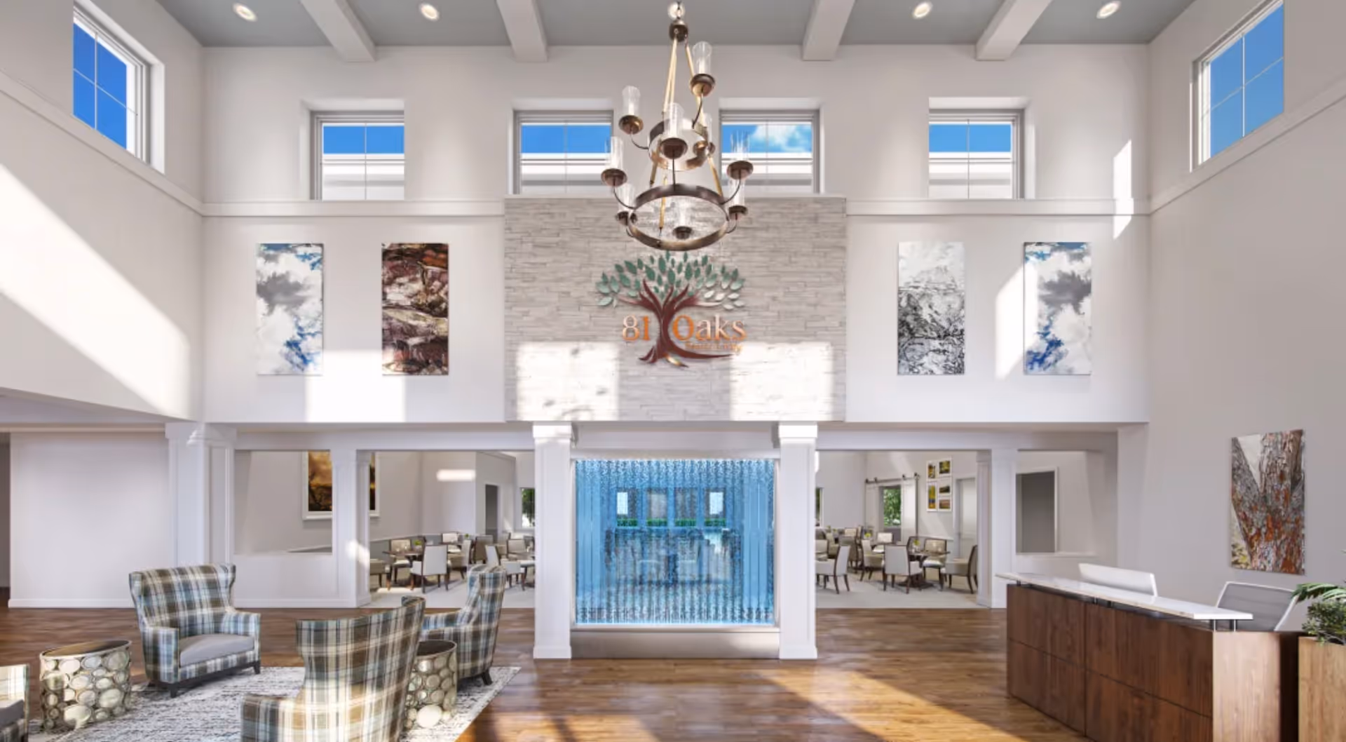 Bright and spacious senior living facility lobby with high ceilings, multiple windows, a chandelier, a water feature, plaid armchairs arranged around small tables on a rug, and a wooden reception desk. The wall behind the water feature displays the 81 Oaks Senior Living logo with decorative artwork on either side.