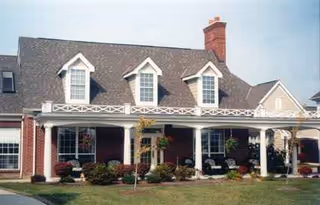 Front view of Elmwood Assisted Living building with a covered porch and dormer windows.
