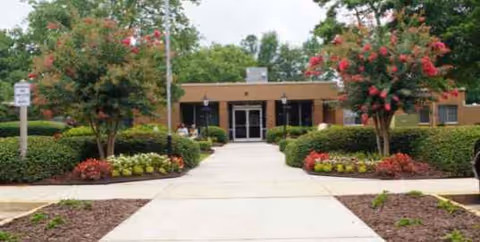 Front view of Lake City Nursing & Rehab Center with landscaped entrance path.