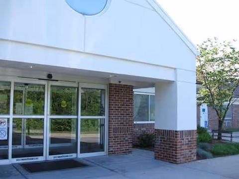Exterior entrance of a medical facility with glass doors and brick columns