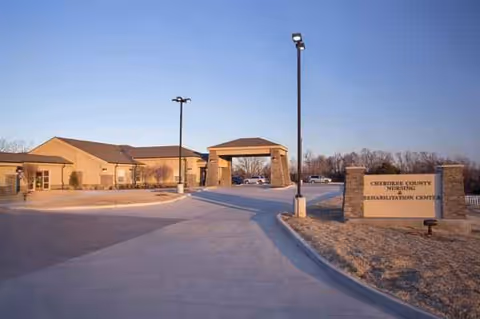 Front exterior view of Cherokee County Nursing Center with driveway and entry sign.