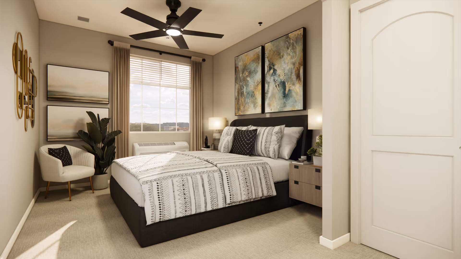 Sunlit furnished bedroom with a bed, patterned bedding, nightstands, an armchair, artwork, and a ceiling fan.