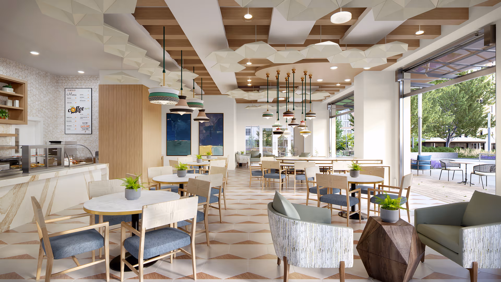A bright and modern dining area with round tables and wooden chairs featuring blue cushions. The ceiling has decorative wooden panels and multiple pendant lights hanging down. There is a counter on the left side with a menu board above it, and large windows on the right side open to an outdoor patio with seating and greenery.
