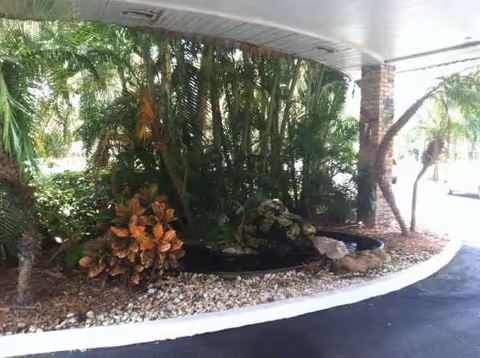 Entrance to Grace Rehabilitation Center with tropical landscaping and curved driveway.