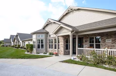 Exterior view of The Waterford at Plymouth, a brick-and-siding senior living facility with lawn.