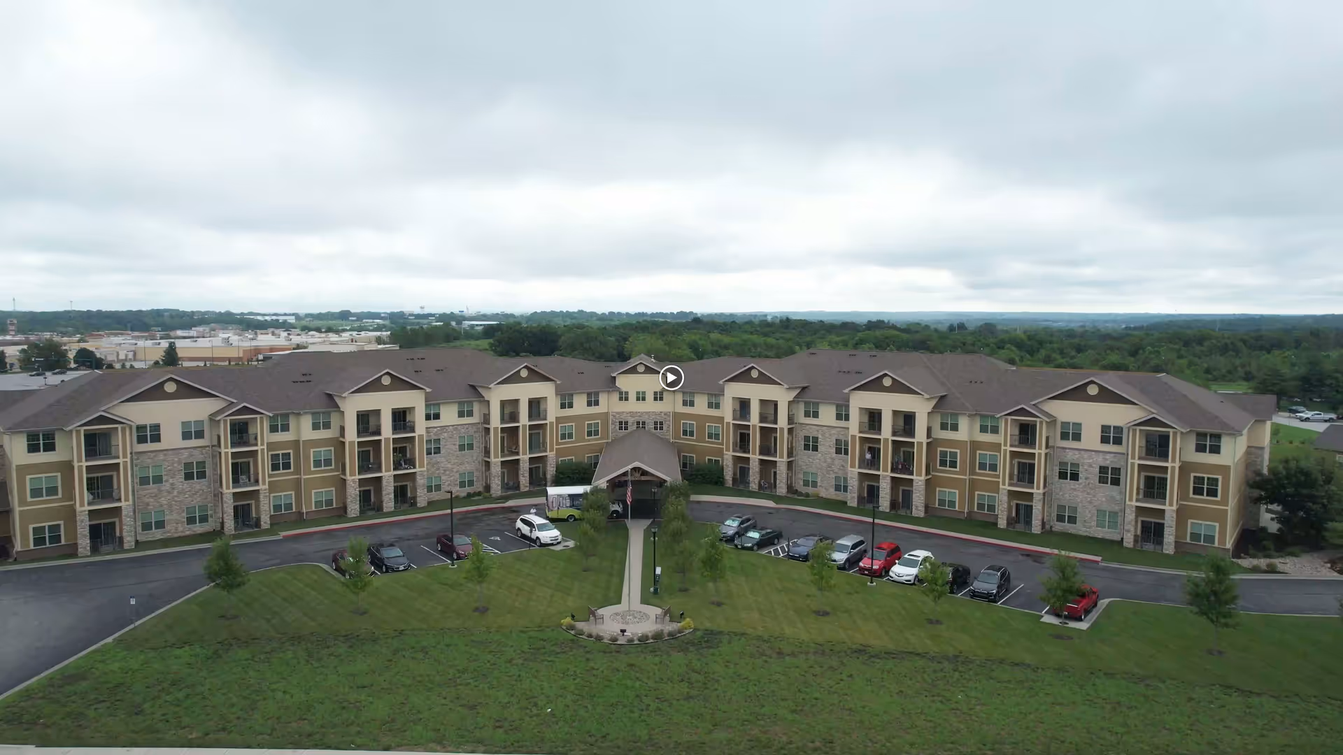 Aerial view of The Parkway Senior Living facility featuring multiple residential building structures and a landscaped parking area.